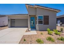 Attractive single Gathering home showcasing desert landscaping, a gray garage door, and a bright blue front door at 17966 W Long Lake Rd, Goodyear, AZ 85338