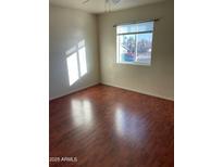 A cozy bedroom featuring wood-look floors and bright natural light from the window at 18239 N 40Th St # 115, Phoenix, AZ 85032