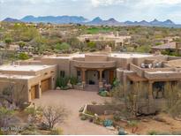 Expansive desert home featuring stucco walls, covered entryway, mature landscaping, and scenic mountain views at 40545 N 109Th Pl, Scottsdale, AZ 85262