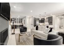 Open-concept living room featuring modern furnishings, a fireplace, a sleek bar, and an adjacent kitchen at 5250 E Deer Valley Dr # 146, Phoenix, AZ 85054