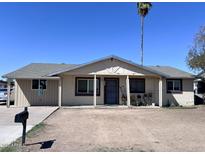 Charming single-story home featuring a cozy front porch, desert landscaping, and a classic mailbox at 7136 W Lewis Ave, Phoenix, AZ 85035