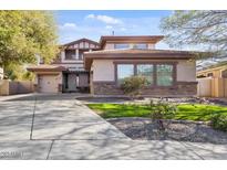 Charming two-story home featuring a landscaped front yard, stone accents, and a spacious driveway leading to the garage at 1093 E Doral Ave, Gilbert, AZ 85297