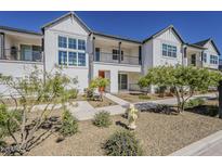 Charming townhome featuring a stylish white facade, manicured landscaping, and a welcoming walkway, ideal for modern living at 11300 N Casa Dega Dr # 1044, Surprise, AZ 85388