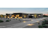 Modern desert home with beautiful desert landscaping, walkway and ambient outdoor lighting at dusk at 36004 N Prickley Pear Rd, Cave Creek, AZ 85331