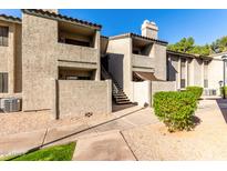 Charming two-story condo with a stucco exterior, stairway access, and desert landscaping at 533 W Guadalupe Rd # 1001, Mesa, AZ 85210