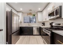 Modern kitchen boasts stainless steel appliances, white cabinets, black lowers, and sleek countertops at 640 E Browning Way, Chandler, AZ 85286
