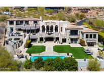 Expansive estate with a pool, perfectly manicured lawn, and luxurious outdoor seating areas and desert views at 7046 N 59Th Pl, Paradise Valley, AZ 85253