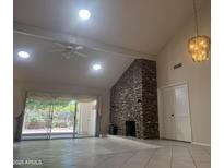 Bright living room with stone fireplace, ceiling fan, and sliding doors to backyard at 8552 E Vía Del Palacio --, Scottsdale, AZ 85258