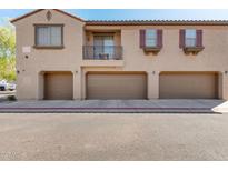 Townhome exterior showing garage doors, small balcony, and neutral color scheme at 1330 S Aaron -- # 186, Mesa, AZ 85209