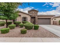 Charming single-story home featuring manicured landscaping, a stone entrance, and a two-car garage at 19571 E Strawberry Dr, Queen Creek, AZ 85142