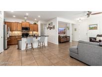 Open-concept home showcases tile floors, barstool seating, kitchen island, and cozy living area at 23005 N 19Th Way, Phoenix, AZ 85024