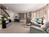 Bright living room featuring neutral walls, plush carpet, and large windows with sheer curtains at 26066 N 72Nd Ave, Peoria, AZ 85383