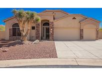 Charming home featuring a well-manicured yard, desert landscaping, and a spacious three-car garage at 4251 N Morning Dove Cir, Mesa, AZ 85207
