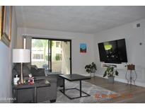 Inviting living room with a modern television set and sliding glass door access to the outside at 10444 N 69Th St # 128, Paradise Valley, AZ 85253