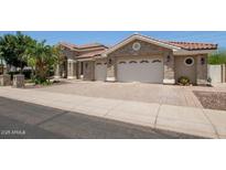 Beautiful home features a paver driveway, stone accents, lush landscaping, and a tile roof at 11054 E North Ln, Scottsdale, AZ 85259