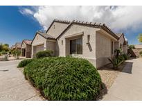 Charming home with a light stucco exterior, tile roof, and lush landscaping at 15885 W Remington Dr, Surprise, AZ 85374