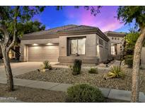 Charming single-story home featuring a desert landscape, a two-car garage, and a neutral color palette at 20933 N 70Th Dr, Glendale, AZ 85308