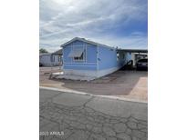 Charming blue mobile home with awning, carport and rock landscaping at 2121 N Center St # 141, Mesa, AZ 85201