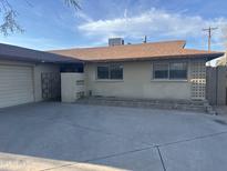 Tan single-story home with mature landscaping and a large concrete driveway at 236 E Minton Dr, Tempe, AZ 85282