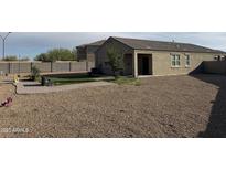 Extensive gravel backyard with desert landscaping, a charming pergola, and a green grass area, creating an inviting outdoor oasis at 29908 W Monterey Dr, Buckeye, AZ 85396