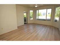 Bright living room featuring wood floors, ceiling fan, large windows, and balcony access at 435 W Rio Salado Pkwy # 210, Tempe, AZ 85281