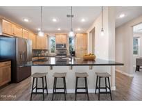 A modern kitchen with stainless steel appliances, granite countertops, and a breakfast bar with seating at 5100 E Rancho Paloma E Dr # 1046, Cave Creek, AZ 85331