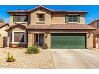 Two-story home with desert landscaping, tile roof, green shutters and a green garage door at 5749 S 249Th Dr, Buckeye, AZ 85326