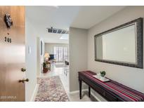 Inviting condo hallway with neutral tones and stylish accents lead into a naturally lit living space at 7960 E Camelback Rd # 209, Scottsdale, AZ 85251