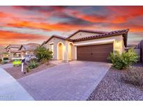 Charming single-story home featuring a paver driveway and desert landscaping under a beautiful sunset sky at 13227 W Crimson Ter, Peoria, AZ 85383