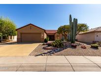 Charming home featuring desert landscaping, a two-car garage, and a red tile roof at 15145 W Woodridge Dr, Surprise, AZ 85374