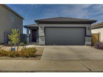 Charming single-story home featuring a two-car garage, desert landscaping, and a welcoming entrance at 17348 W Patrick Ln, Surprise, AZ 85387