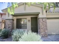 Charming home exterior featuring a green front door with stone accents, and desert landscaping at 1935 W Periwinkle Way, Chandler, AZ 85248