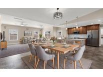 Spacious dining room features a modern light fixture, dining table and seating for a large gathering at 3747 E Harmony Ave, Mesa, AZ 85206