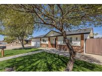 Charming single-story home featuring a manicured lawn and a brick-accented facade at 4646 E Contessa St, Mesa, AZ 85205