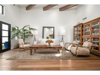 Bright living room with wood floors, exposed beams, and comfortable, elegant furnishings at 5101 N Casa Blanca Dr # 217, Paradise Valley, AZ 85253