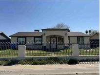 Charming single-story home featuring a secure iron fence enhancing curb appeal at 6531 W Granada Rd, Phoenix, AZ 85035