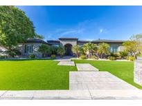 Beautiful home featuring a well-manicured lawn, desert landscaping, and a grand entrance at 7150 E Balfour Rd, Paradise Valley, AZ 85253