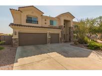 Elegant two-story home with a three-car garage and beautiful desert landscaping at 10922 N 153Rd Ln, Surprise, AZ 85379