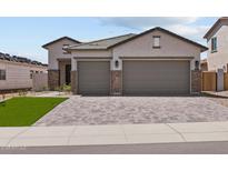 Charming single-Gathering home featuring a paved driveway, two-car garage and appealing stone accents at 19323 W San Juan Ave, Litchfield Park, AZ 85340