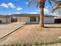 Charming single-story home with a carport, a mature palm tree and freshly painted exterior at 2224 E Glade Ave, Mesa, AZ 85204