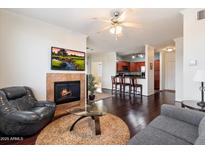 Inviting living room featuring a fireplace, dark wood floors, and a ceiling fan, perfect for relaxing and entertaining at 7009 E Acoma, Lot #2060 Dr # 2060, Scottsdale, AZ 85254