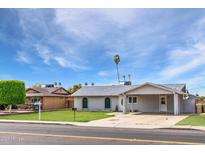 Charming single-story home featuring a well-maintained lawn, covered parking, and desert landscaping at 9716 N 55Th Ave, Glendale, AZ 85302