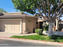 Tan home with a well-kept lawn, a large tree and a two-car garage in a sunny neighborhood at 18002 N 12Th St # 19, Phoenix, AZ 85022