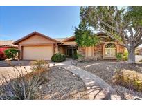 Charming single-story home featuring a stone facade, well-maintained landscaping, and a welcoming walkway at 19021 N 90Th Ln, Peoria, AZ 85382