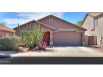 Charming single-story home featuring desert landscaping and a neutral stucco exterior with a two car garage at 21424 N Howell Dr, Maricopa, AZ 85138