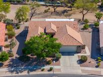 Aerial view of single-story home with tile roof, mature landscaping, and a two-car garage at 2381 E Firerock Dr, Casa Grande, AZ 85194