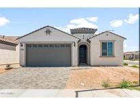 Charming single-story home featuring a gray two-car garage door, neutral paint, and desert landscaping at 26995 W Adam Ave, Buckeye, AZ 85396