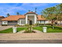 Charming home featuring a red tile roof, a lush lawn, and well-manicured landscaping at 2924 E Mallory St, Mesa, AZ 85213