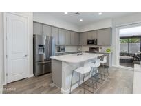Modern kitchen with stainless steel appliances, gray cabinets, an island with bar seating and pendant lights at 3045 N 37Th Way, Phoenix, AZ 85018