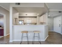 A kitchen bar with sleek stools adds casual seating and style to the space at 3236 E Chandler Blvd # 3078, Phoenix, AZ 85048